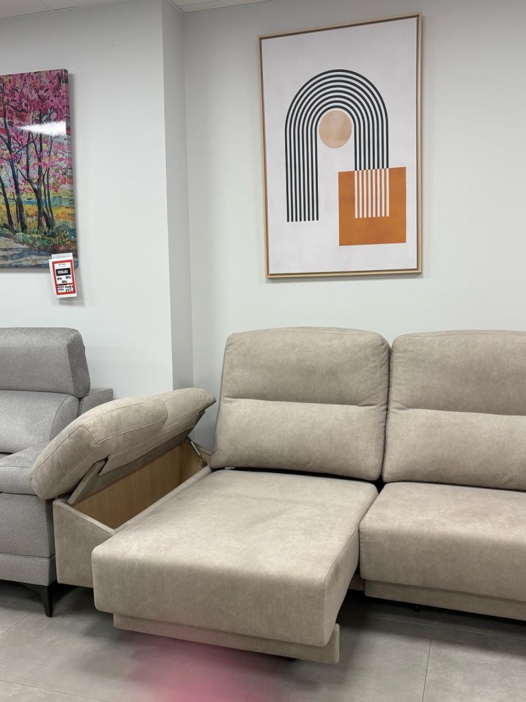Sofá de dimensiones reducidas bajo cuadro moderno, ideal para apartamentos